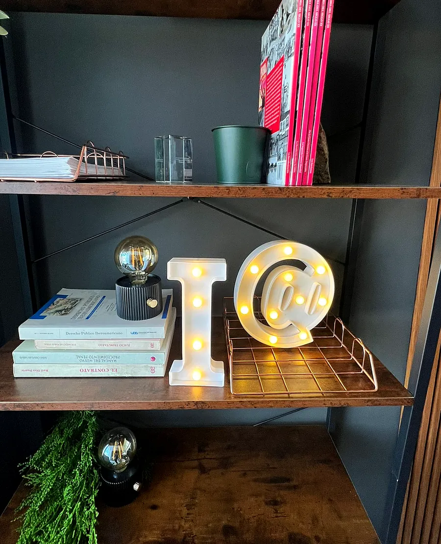 Detalle del set: repisa con libros de derecho y luces cálidas